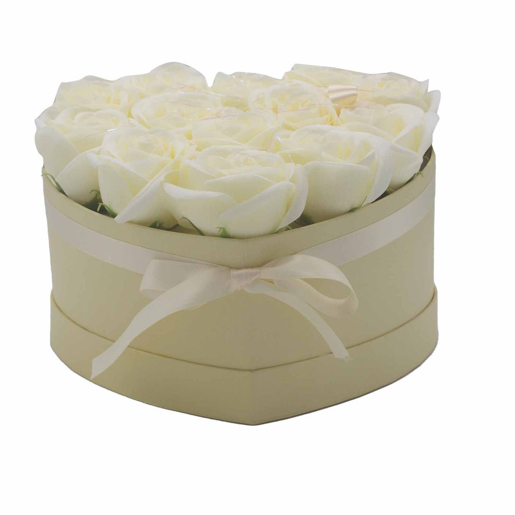 Heart-shaped box with white roses and a bow on a white background