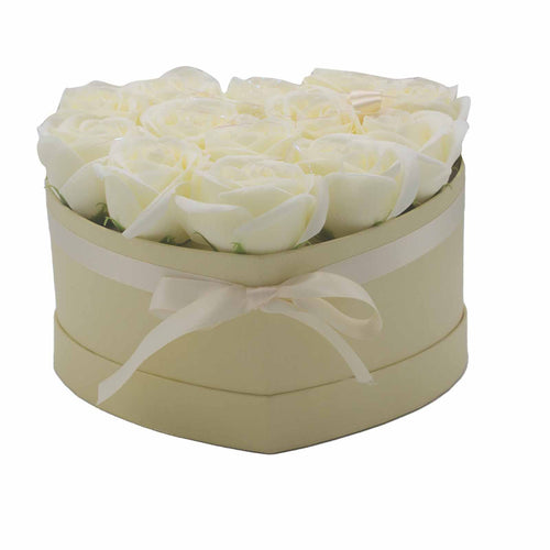 Heart-shaped box with white roses and a bow on a white background