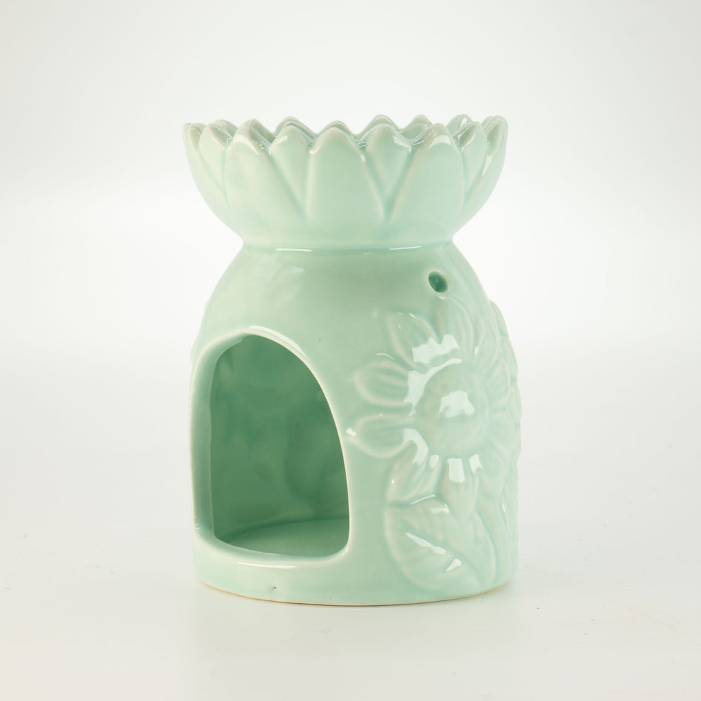 Mint green ceramic oil burner with floral design on a white background
