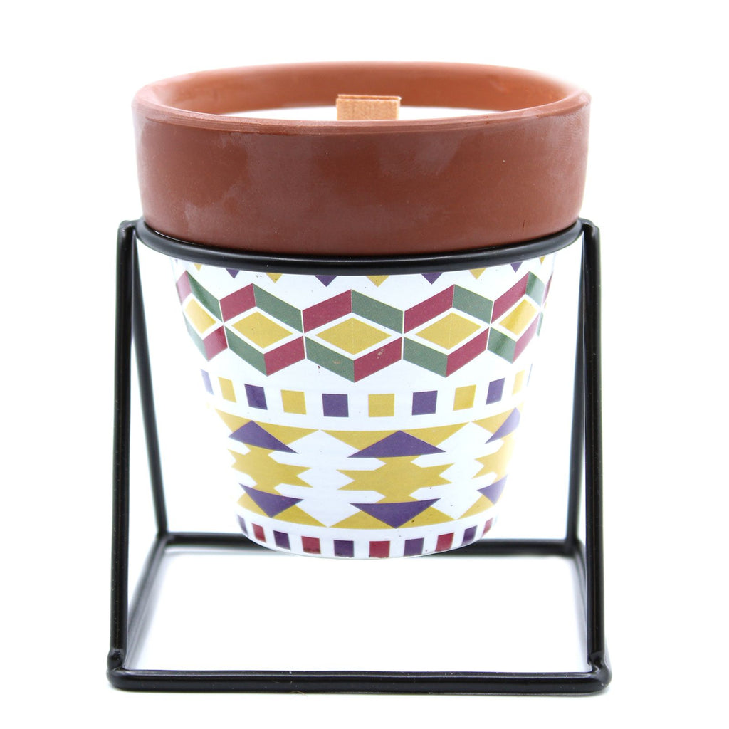 Ceramic pot with geometric pattern on a stand against a white background