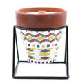 Ceramic pot with geometric pattern on a stand against a white background