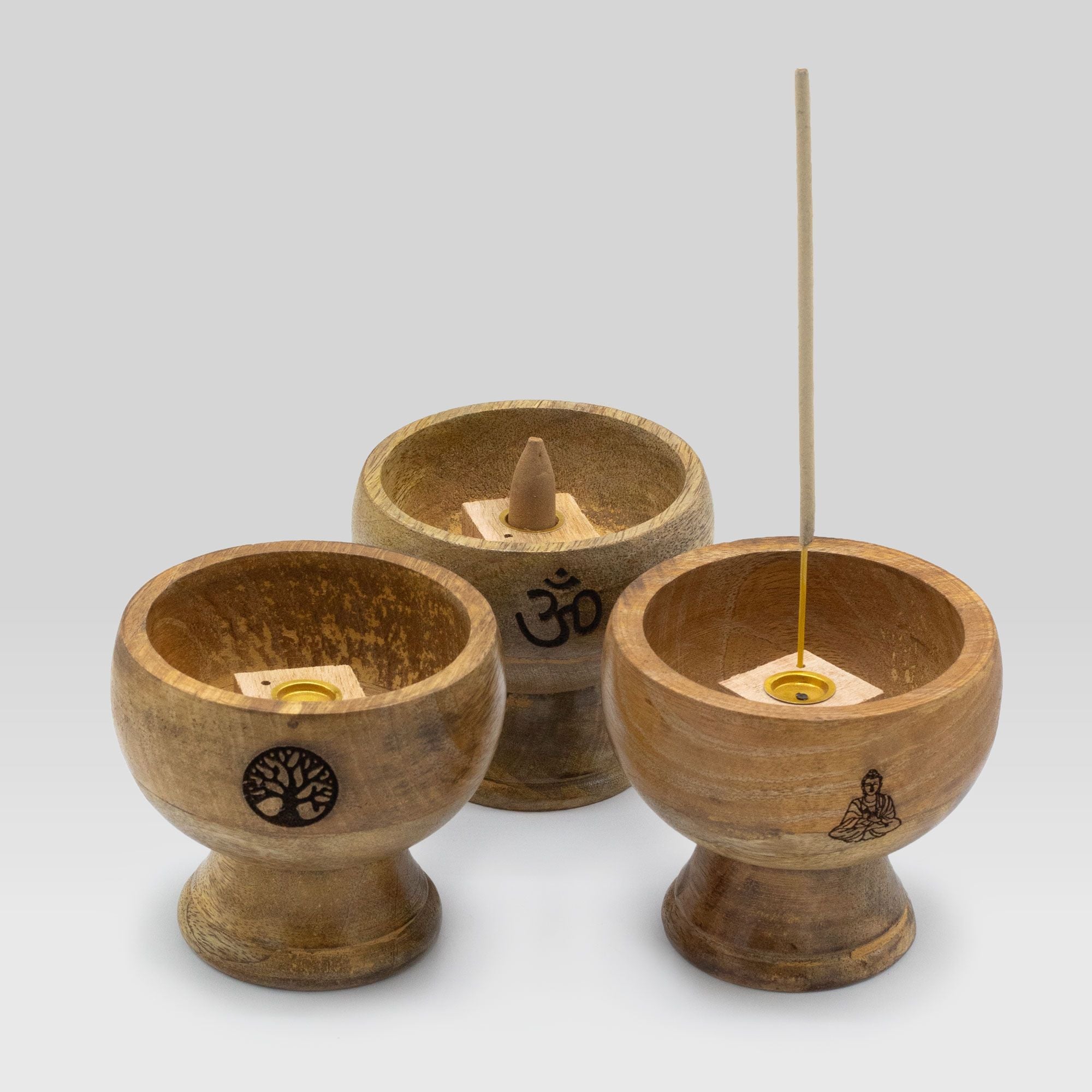 Three wooden incense holders with incense sticks on a white background