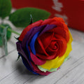 Colourful rose made of soap on a wooden surface