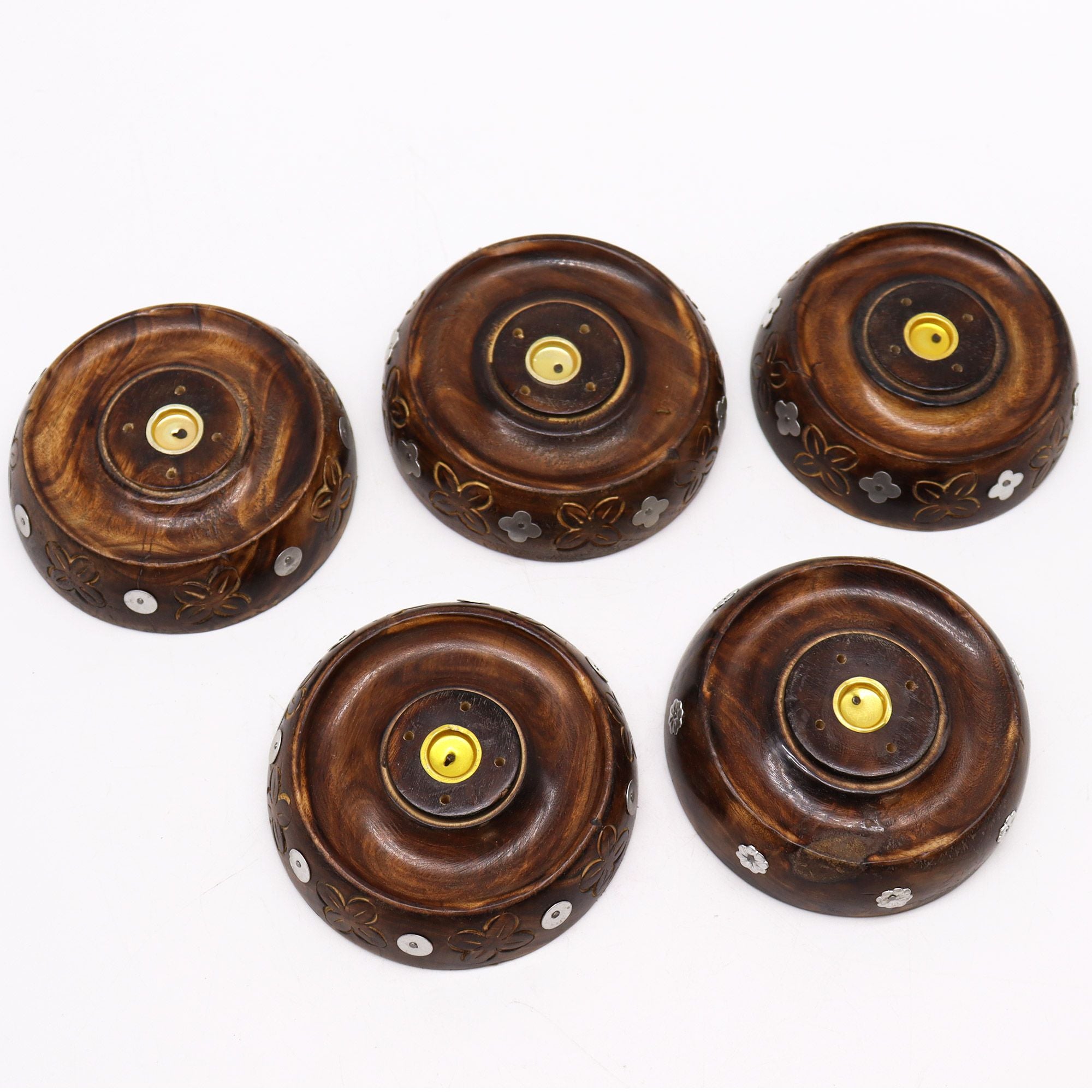 Five wooden incense holders with decorative patterns on a white background