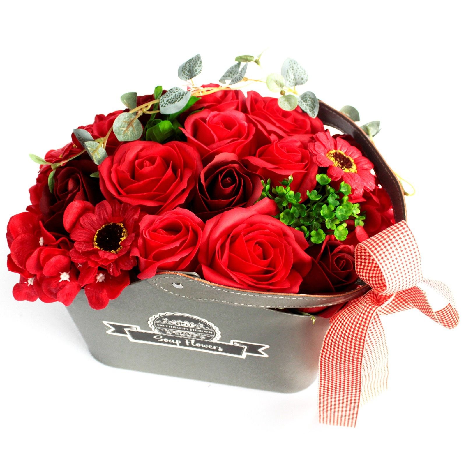 Bouquet of red roses with greenery in a decorative container on a white background